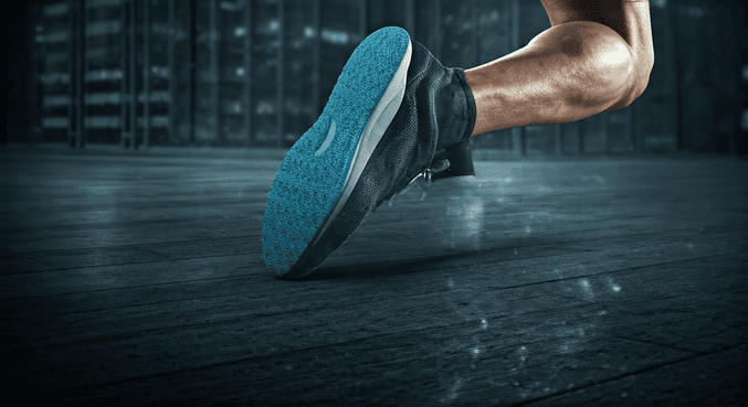 alt_text: Osoba skacze na trampolinie w słoneczny dzień, trenując spalanie kalorii wśród zieleni.