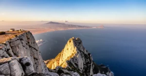 Widok z wierzchołka Skały Gibraltarskiej na Cieśninę Gibraltarską i wybrzeże Afryki w ciepłym świetle zachodzącego słońca.