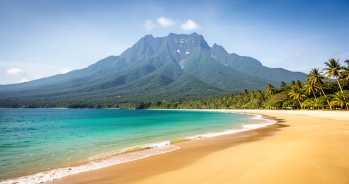 Piaszczysta plaża z turkusową wodą w Kota Kinabalu, w tle widoczny majestatyczny masyw góry Kinabalu pod bezchmurnym niebem.